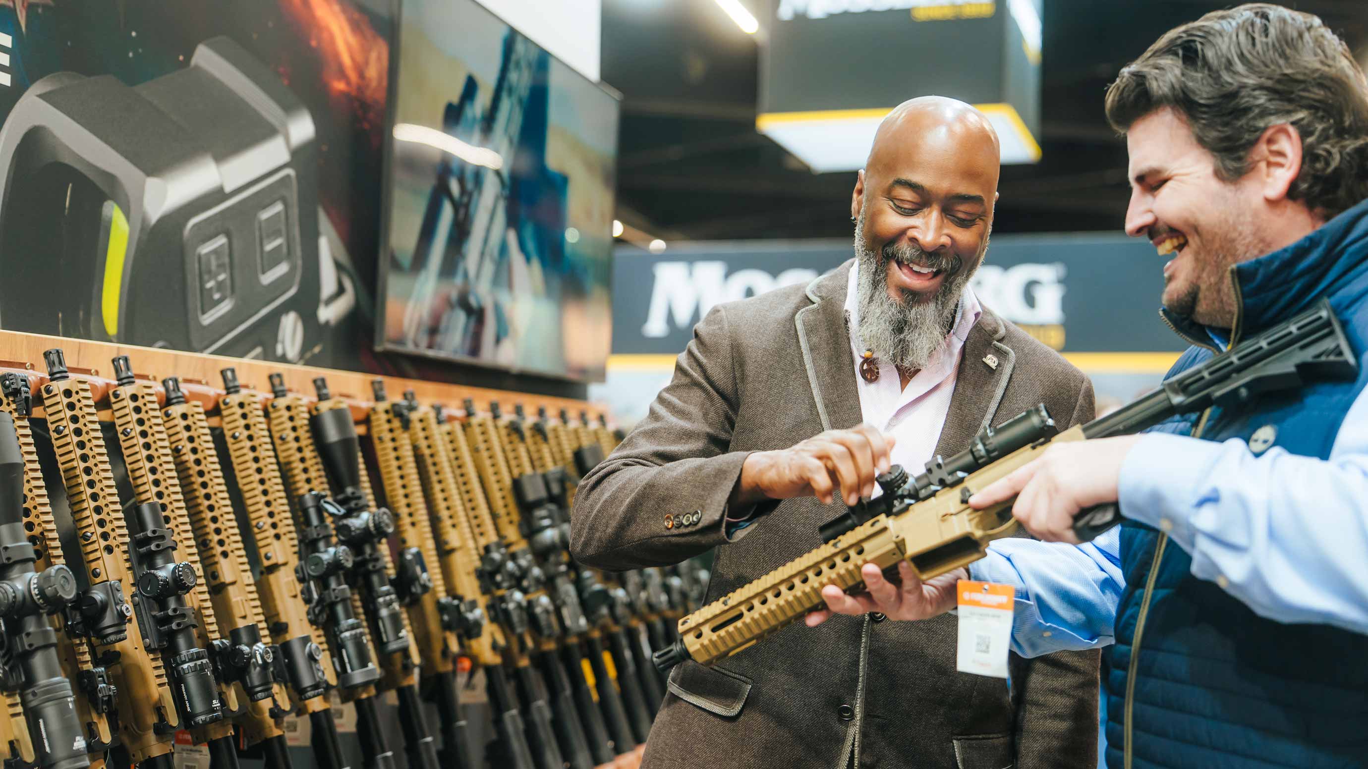 Two men talking about a long gun